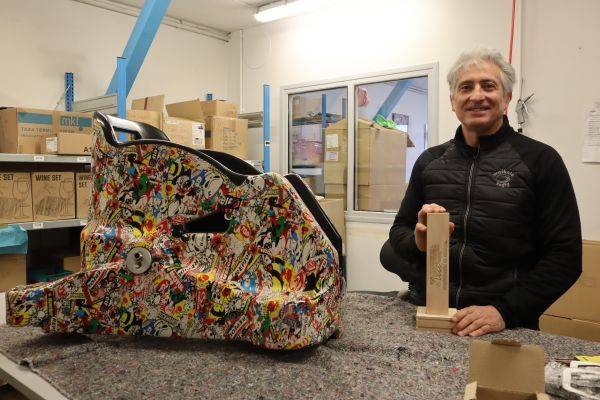 Jeff Impinna avec ses coques de fauteuils roulants et son trophée